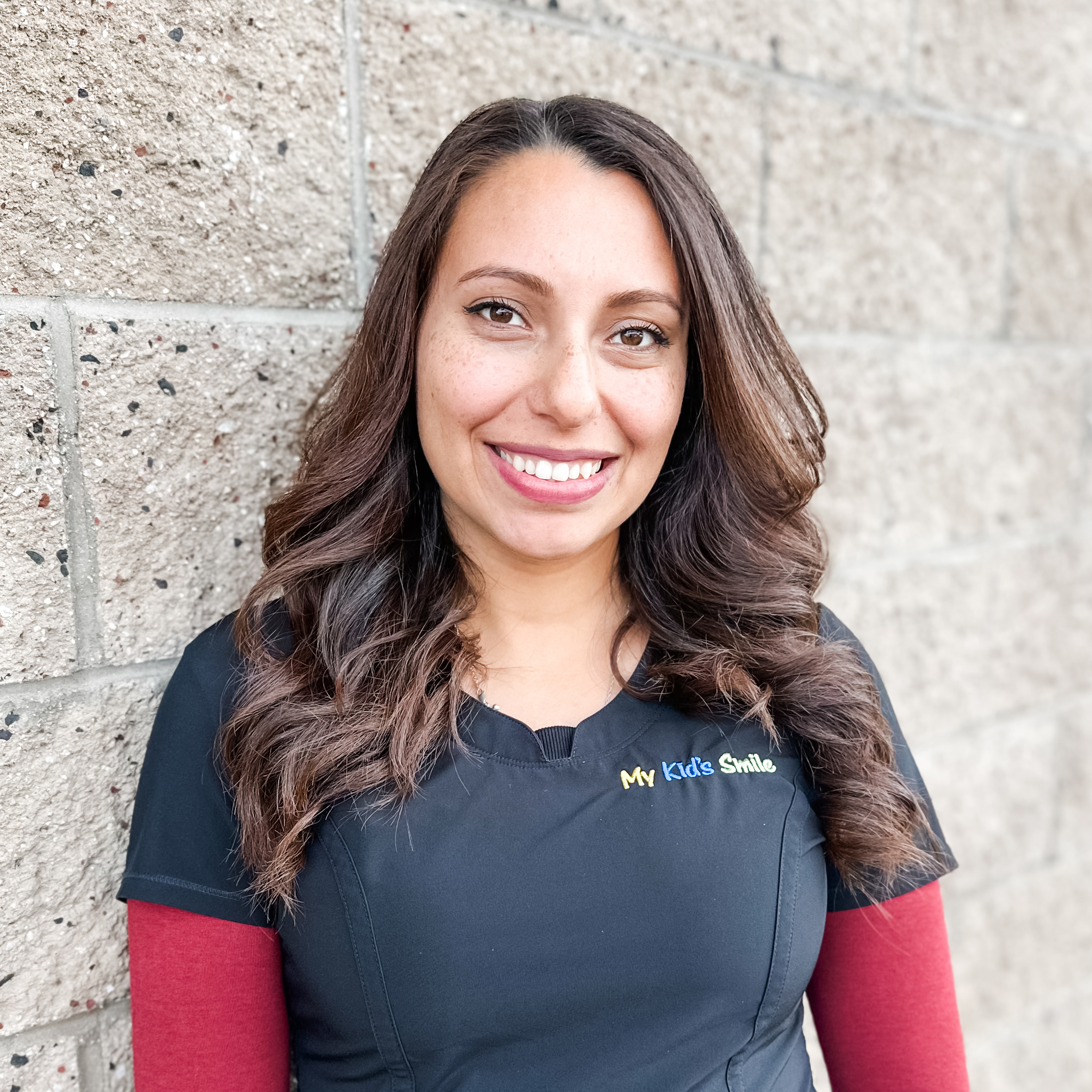 Smiling woman with long hair, textured wall background