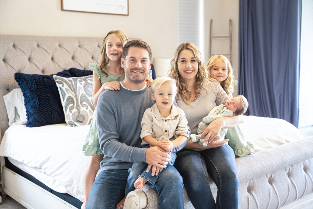 Happy family sitting together on bed.